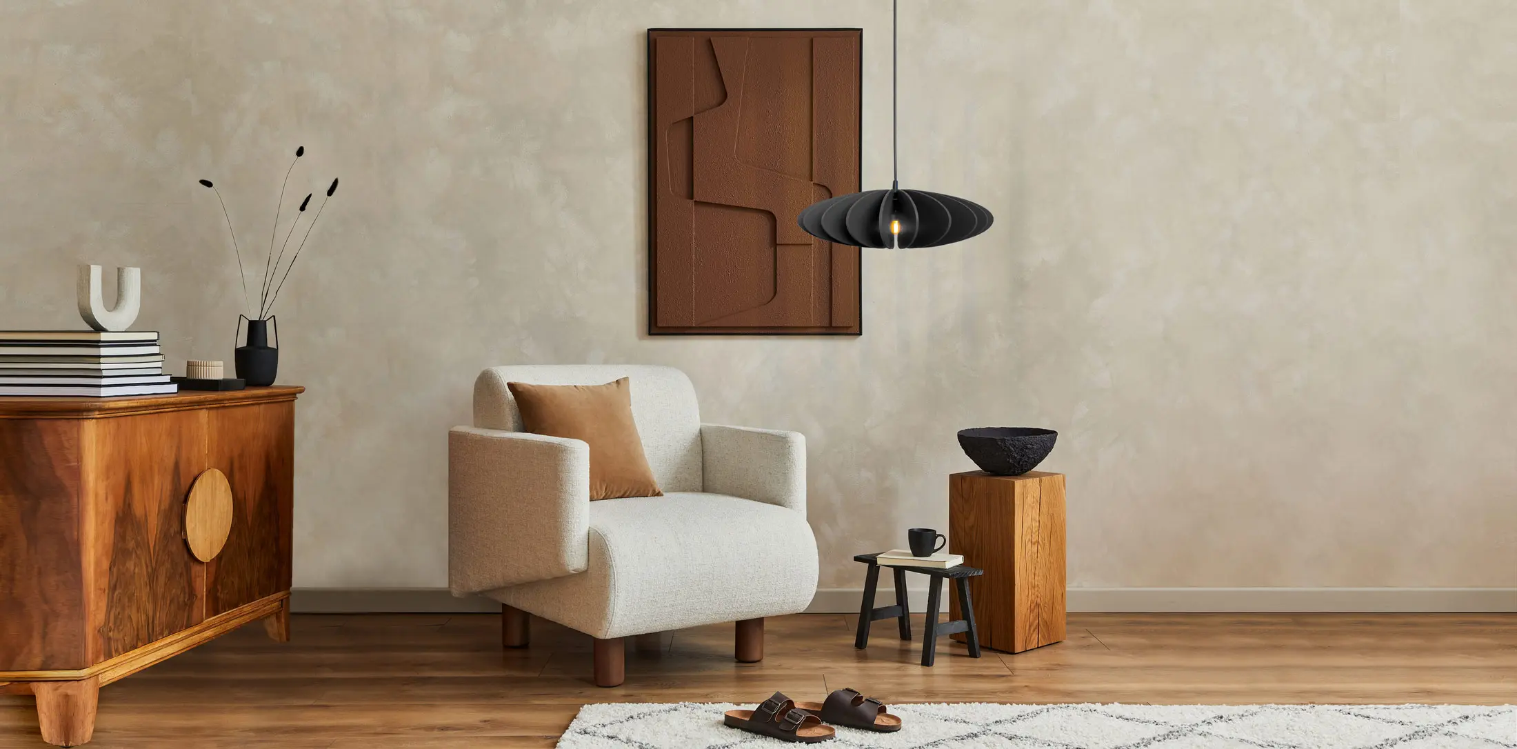 Stilvoll eingerichtetes Wohnzimmer mit moderner CAHAYA Pendelleuchte, Skulptur auf Holztisch und gemütlichem Sessel von Jennifer Miller